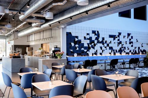 a dining room with tables and chairs and a wall with squares at Comfort Hotel Porsgrunn in Porsgrunn
