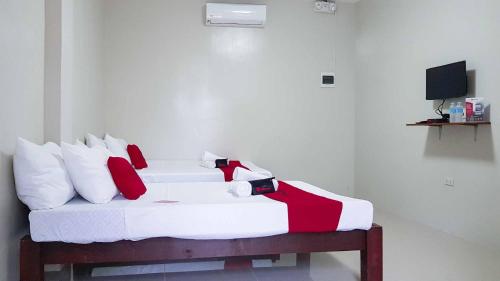 タグビラランにあるRedDoorz @ VP Inting Streetのベッドルーム1室(赤と白の枕が備わるベッド1台付)