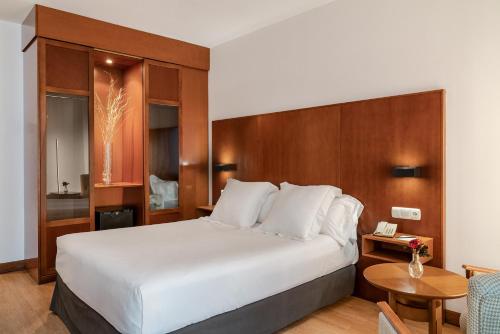una camera d'albergo con un letto grande e un tavolo di Vincci Ciudad de Salamanca a Salamanca