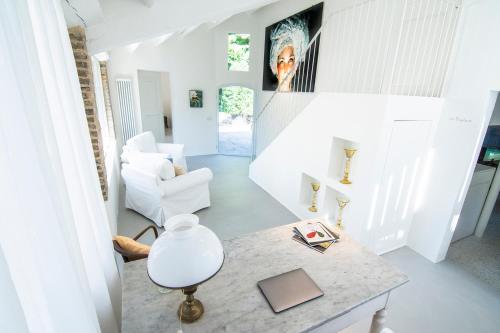 a white living room with a table and a chair at DelleFarfalle Boutique B&B in Santarcangelo di Romagna