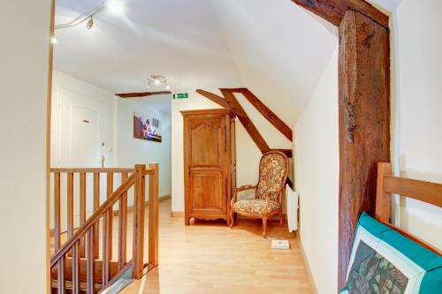 einen Flur mit Stuhl und Treppe in einem Haus in der Unterkunft Auberge Saint Fergeux in Gionges