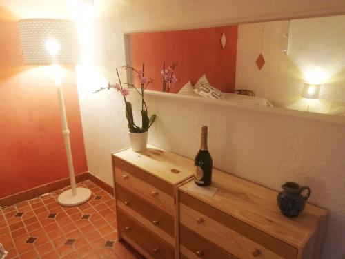 Un dormitorio con una botella de vino en un tocador y un espejo en Domaine des Goudis en Bouisse