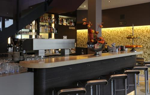 a bar with bar stools in a restaurant at KH Hotel mit Restaurant in Geisenfeld