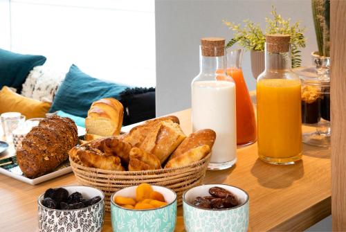 a table with a basket of bread and bottles of milk at Hôtel Eiffel Saint Charles in Paris