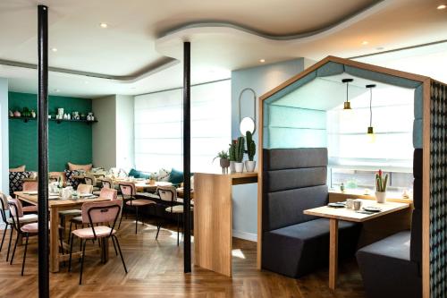 a restaurant with tables and chairs in a room at Hôtel Eiffel Saint Charles in Paris