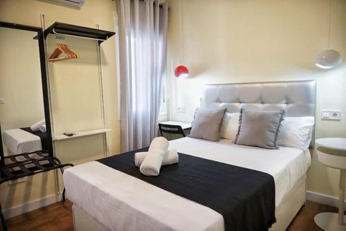 1 dormitorio con 1 cama blanca grande en una habitación en Good Stay Rooms, en Madrid