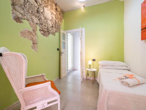 Una habitación con dos camas y una silla dentro. en Appartamento L'arcobaleno, en Cagliari
