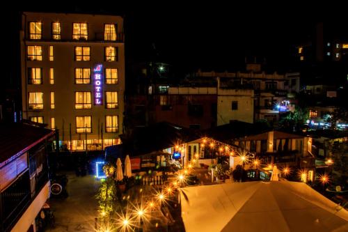 a city at night with a building with a purple sign at M Hotel Thamel-Kathmandu in Kathmandu