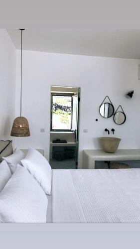 Un dormitorio blanco con una cama y una ventana. en Nice Villas Pyrgos, en Pirgos