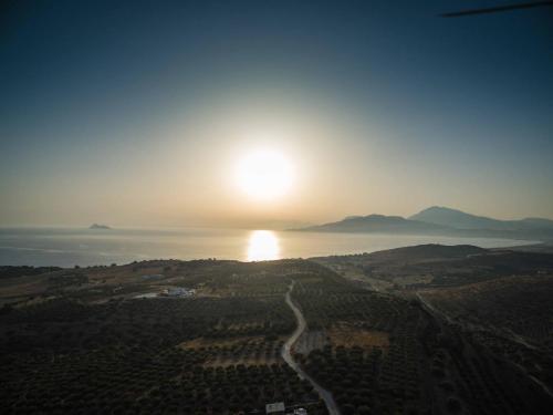 an aerial view of the sun setting over the ocean at Villa Diana in Pitsidia