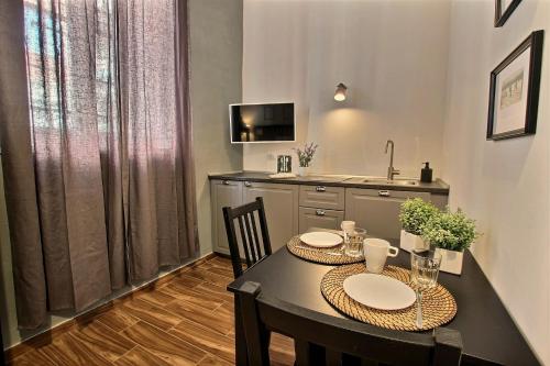 a dining room with a table and chairs and a kitchen at La Ca' di sogn in Pavia