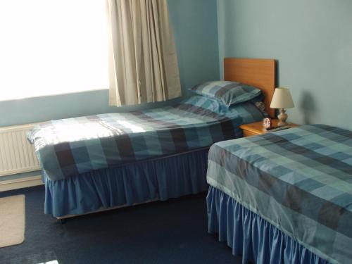 a hotel room with two beds and a window at The Windsor in Haverfordwest