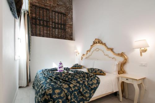 a bedroom with a white bed with a gold frame at Al Mascaron Ridente in Venice