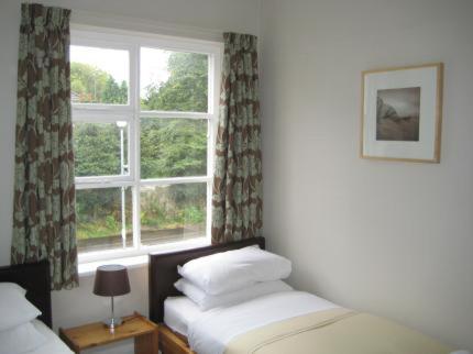 a bedroom with two beds and a window at The Kings Arms in Wilmslow