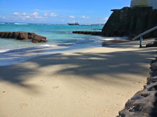 a beach with a large shadow of a tree on it at Villa Anjani - Ocean view Villa, With Private Garden and Cook - Candidasa in Candidasa
