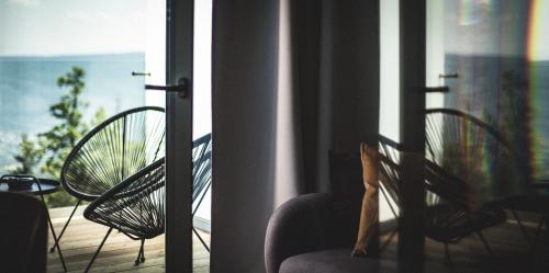 a balcony with two chairs and a view of the ocean at Ski&Sun Apartamenty in Świeradów-Zdrój