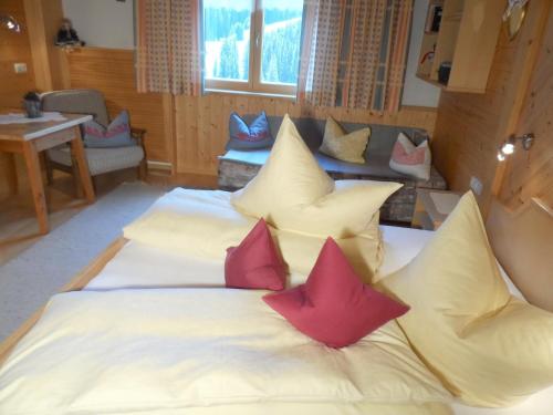 a bed in a room with pillows on it at Haus Brunneck in Warth am Arlberg