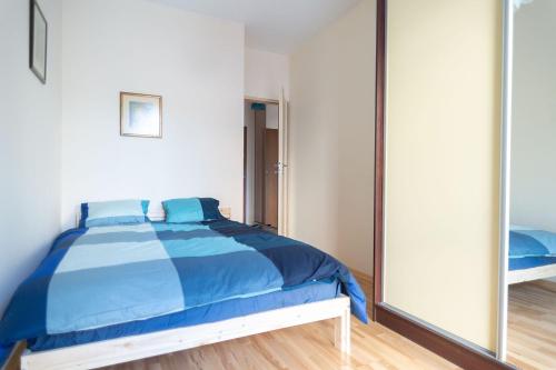 una camera con letto blu e specchio di Apartament w cichej okolicy 5 minut od centrum a Danzica