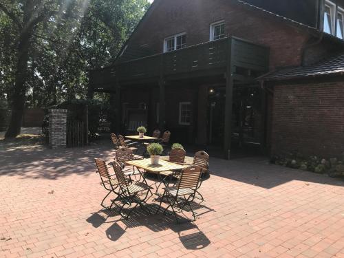 a patio with a table and chairs in front of a building at Landcafe Neumann in Bad Zwischenahn