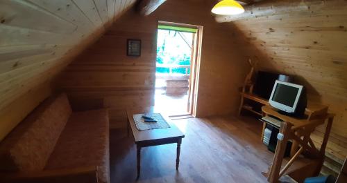 una camera con tavolo e televisore in una cabina di ŠMITI a (( Čūskumuiža ))