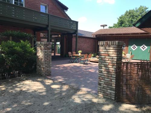 eine Terrasse eines Hauses mit einem Tisch und Stühlen in der Unterkunft Landcafe Neumann in Bad Zwischenahn
