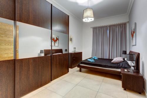 - une chambre avec un lit et un mur en bois dans l'établissement Gorgeous Apartment with Terrace in Fort Cambridge, Pool, à Sliema