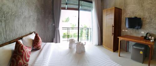 a bedroom with a bed with two teddy bears on it at JR Place in Klong Muang Beach