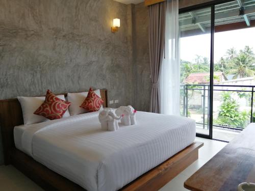 a bedroom with a bed with two teddy bears on it at JR Place in Klong Muang Beach