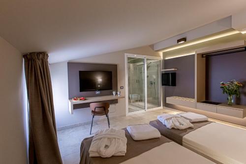 a hotel room with two beds and a television at Charme SIMON BOLIVAR in Noto