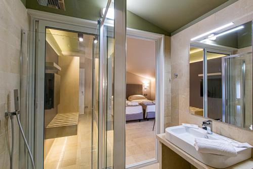a bathroom with a sink and a shower and a bedroom at Charme SIMON BOLIVAR in Noto