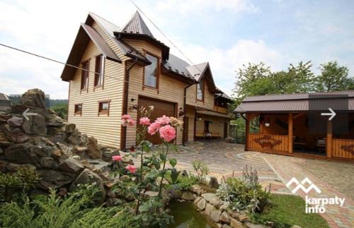 a wooden house with a garden and a house at Садиба Надія in Sheshory