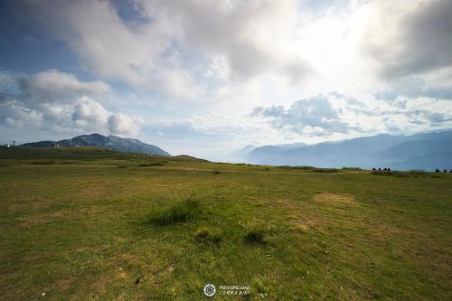 a large open field with a mountain in the background at Albergo Rifugio Graziani in Brentonico
