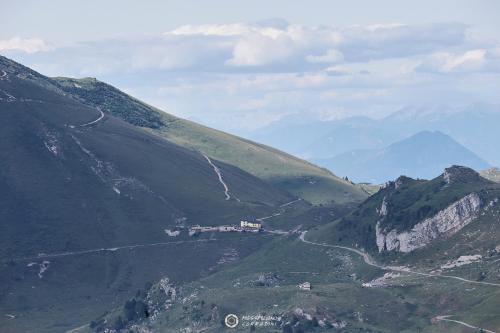 a view of a mountain valley with a house on it at Albergo Rifugio Graziani in Brentonico