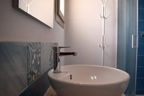 a bathroom with a white sink and a mirror at Corallo Rooms in Budoni