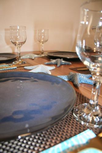 a table with a plate and wine glasses on it at Floating House Marina Royal in Portorož