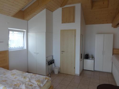 a bedroom with white walls and a bed and a window at Bed and Breakfast Prilly-Lausanne in Prilly