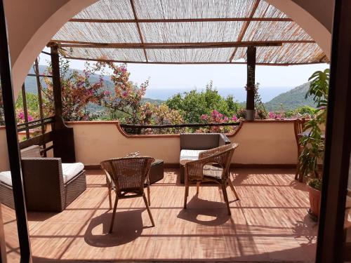 a patio with chairs and a table and a view at Casa de rosa in Palinuro