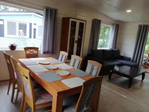 a dining room with a wooden table and chairs at Domek letniskowy - czerwony całoroczny in Stegers