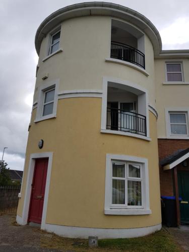 un edificio blanco y amarillo con una puerta roja en Spacious House in Castlegar Galway en Galway