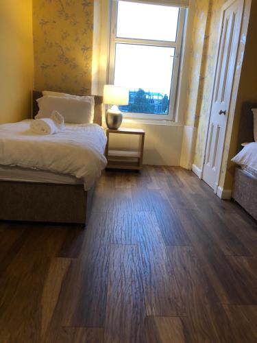 a bedroom with a bed and a large window at St Margaret's Loch Apartment in Edinburgh