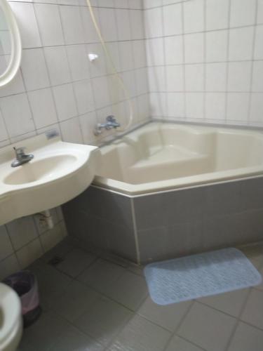 a bathroom with a sink and a bath tub next to a toilet at 知本喻禾溫泉民宿 in Wenquan