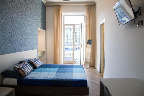 een slaapkamer met een bed en een groot raam bij Garibaldi Rooms in Napels
