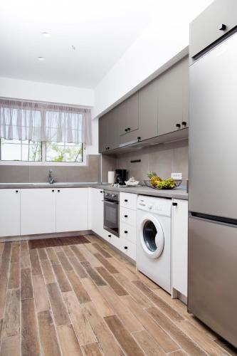 a kitchen with white cabinets and a dishwasher at Elenis Philoxenia in Ixia