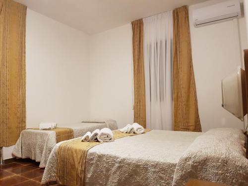 um quarto com 2 camas e toalhas em Villa Giada-8 appartamenti em Leporano