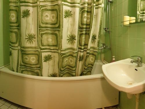 a bathroom with a shower curtain and a sink at Apartment 6 Mikrorayon in Kurgan