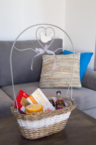 a basket on a table with food on a couch at Elenis Philoxenia in Ixia