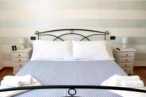 1 dormitorio con 1 cama y 2 toallas blancas en Casa vacanze Beach House vicino alla stazione en La Spezia