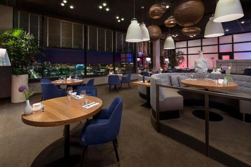 een restaurant met tafels en stoelen en uitzicht op de stad bij WestCord WTC Hotel Leeuwarden in Leeuwarden