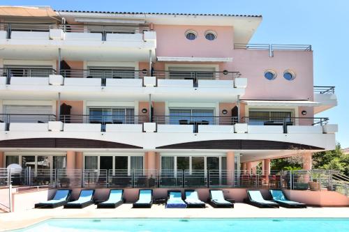 a building with a swimming pool in front of a building at Zenitude Hôtel-Résidences Le Cannet in Le Cannet