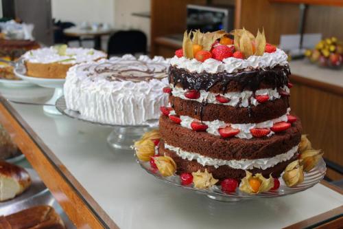 a chocolate cake with fruit on top on a table at HD Plaza Hotel in Assis